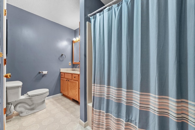 bathroom with vanity, toilet, baseboards, and tile patterned flooring