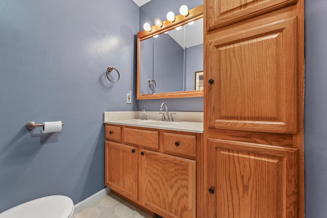 bathroom featuring baseboards, toilet, and vanity