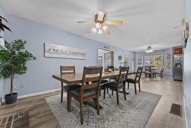 dining area with ceiling fan, wood finished floors, visible vents, and baseboards