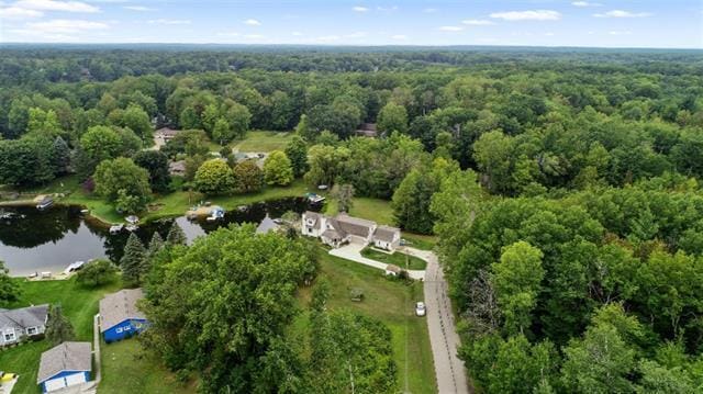 birds eye view of property with a view of trees and a water view