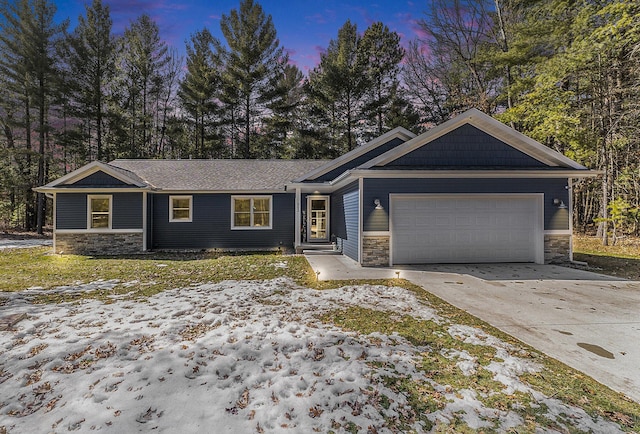 view of front of property with a garage, stone siding, and driveway