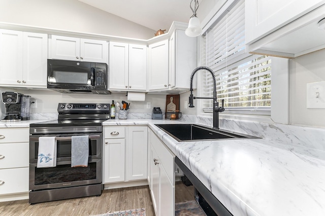 kitchen with black microwave, lofted ceiling, electric range, white cabinets, and a sink