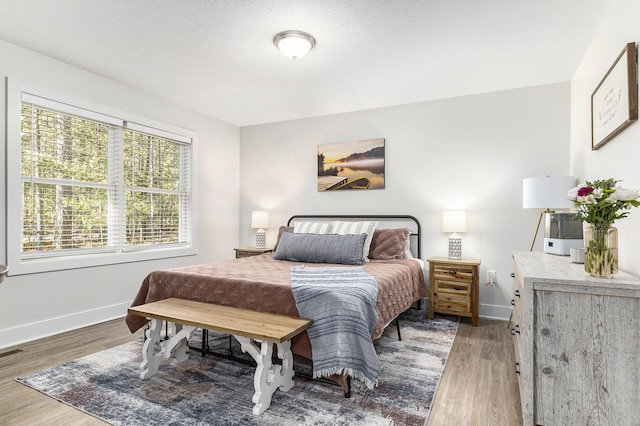 bedroom with wood finished floors and baseboards