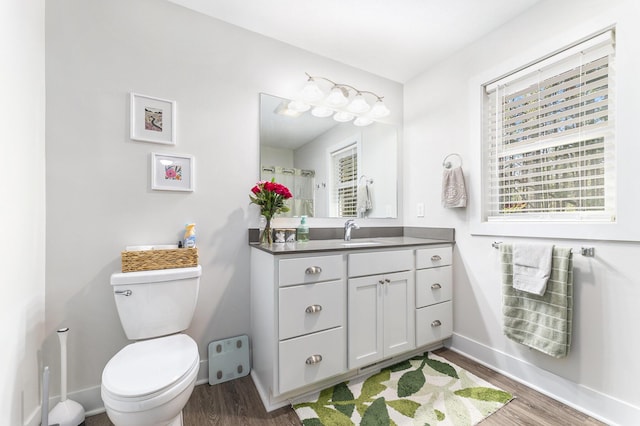 bathroom with baseboards, toilet, and wood finished floors