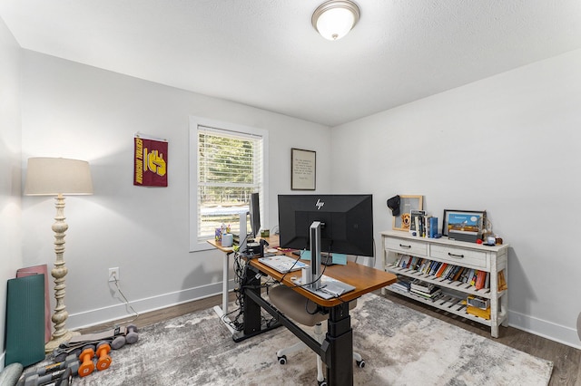 office space featuring wood finished floors, baseboards, and a textured ceiling