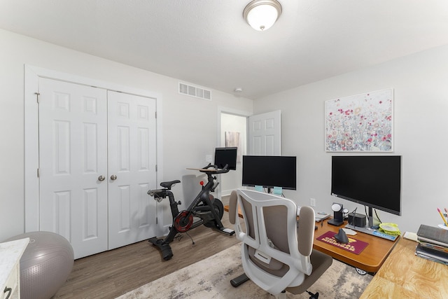 office area featuring visible vents and wood finished floors