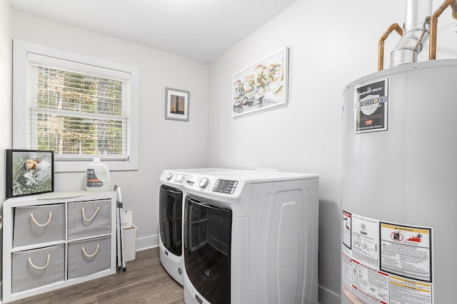 laundry area featuring baseboards, washing machine and dryer, gas water heater, laundry area, and wood finished floors