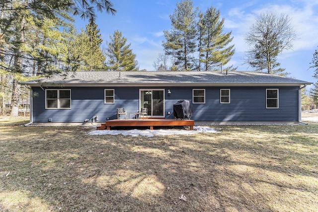 back of property with a yard and a deck