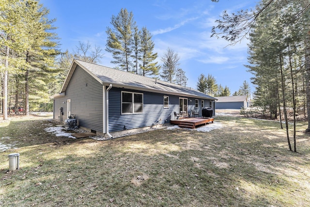 view of front facade with a wooden deck, a front yard, and a shingled roof
