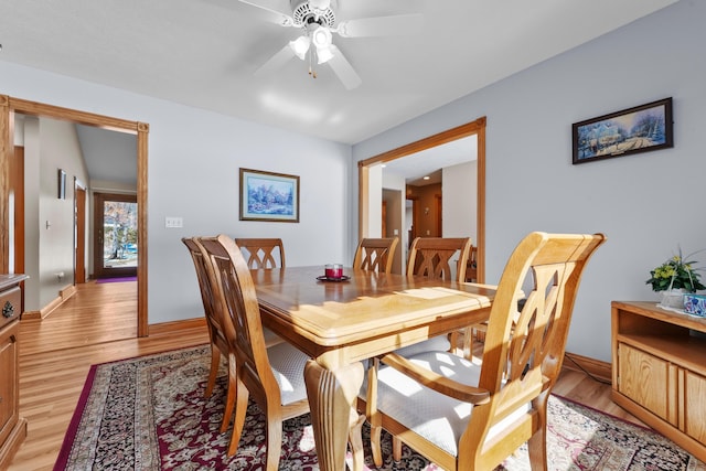 dining area featuring baseboards, light wood-style flooring, and a ceiling fan