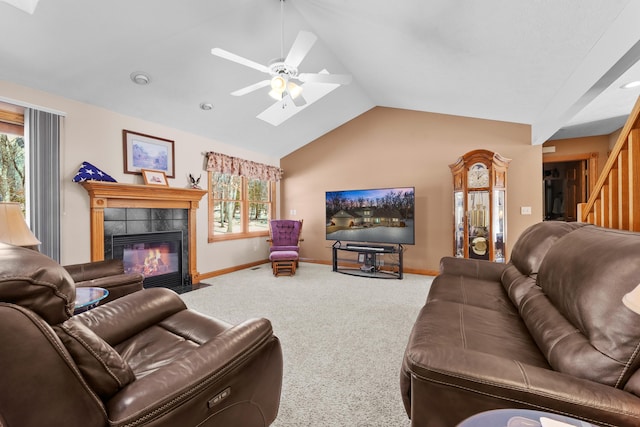 carpeted living area with a tiled fireplace, lofted ceiling, a ceiling fan, and baseboards