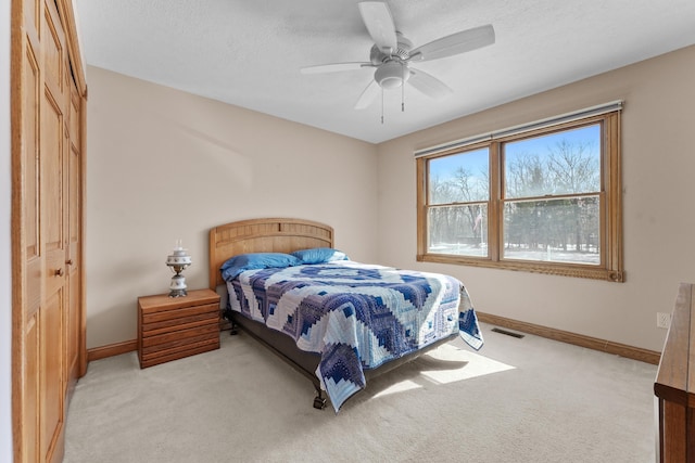 bedroom with light carpet, visible vents, a textured ceiling, and baseboards