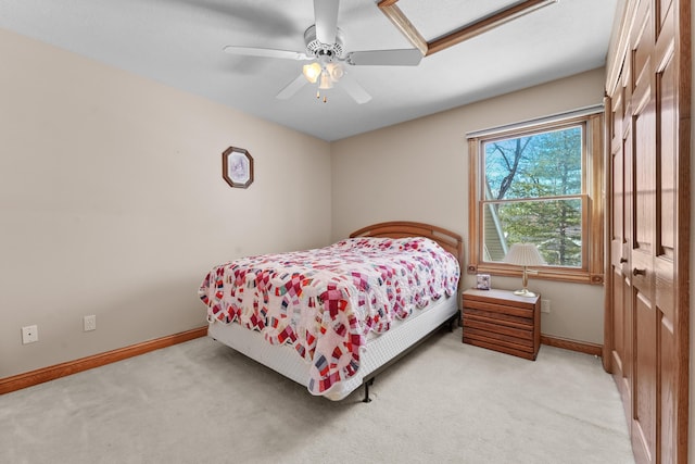 bedroom featuring light colored carpet, baseboards, and ceiling fan