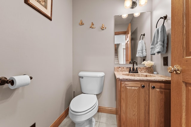 bathroom with tile patterned flooring, toilet, vanity, and baseboards