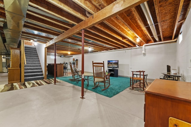 finished basement with stairway and concrete block wall