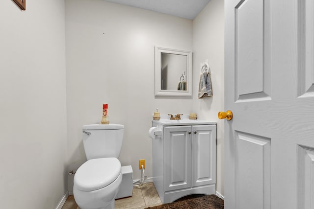 half bathroom featuring baseboards, toilet, and vanity