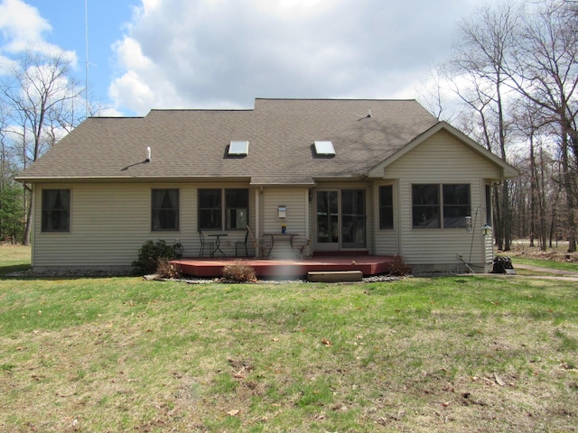 back of property with roof with shingles, a yard, and a wooden deck