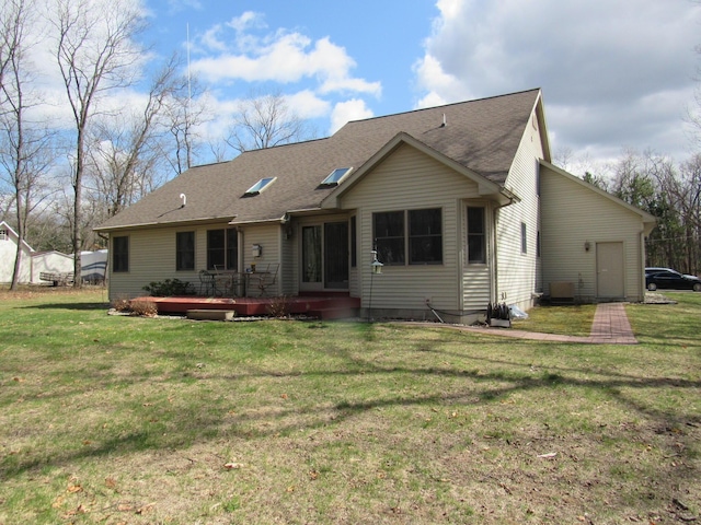 view of front of house with roof with shingles, a deck, and a front lawn