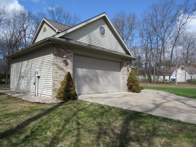 view of property exterior featuring brick siding, driveway, an attached garage, and a lawn