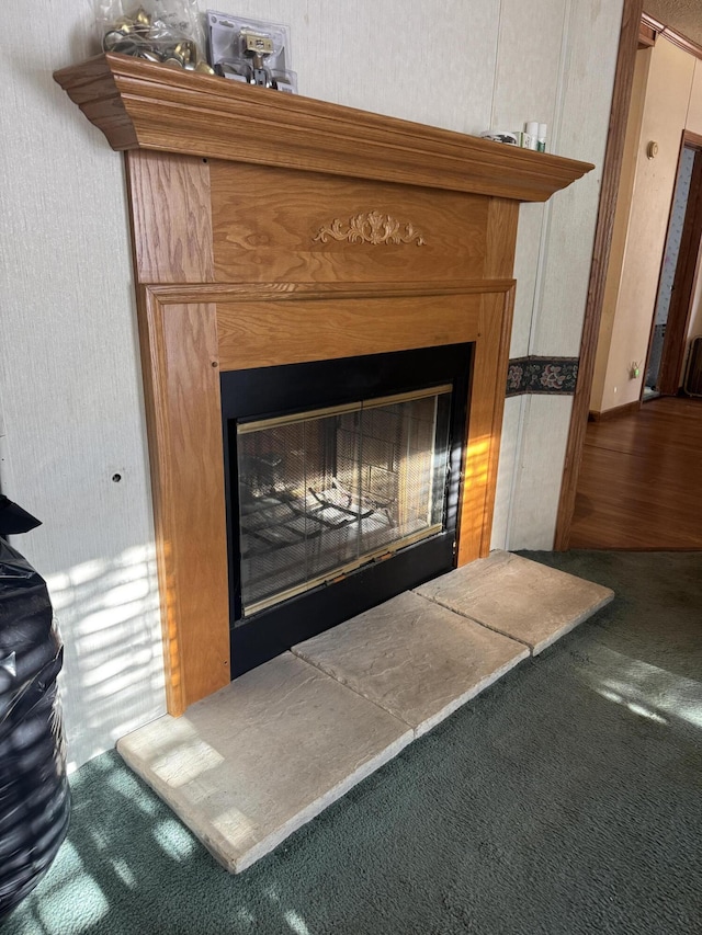 room details with a glass covered fireplace and carpet flooring