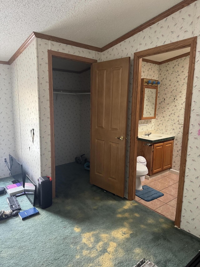 bedroom featuring a textured ceiling, crown molding, and wallpapered walls