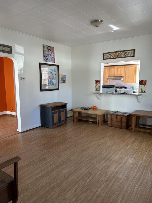 unfurnished dining area featuring wood finished floors and arched walkways