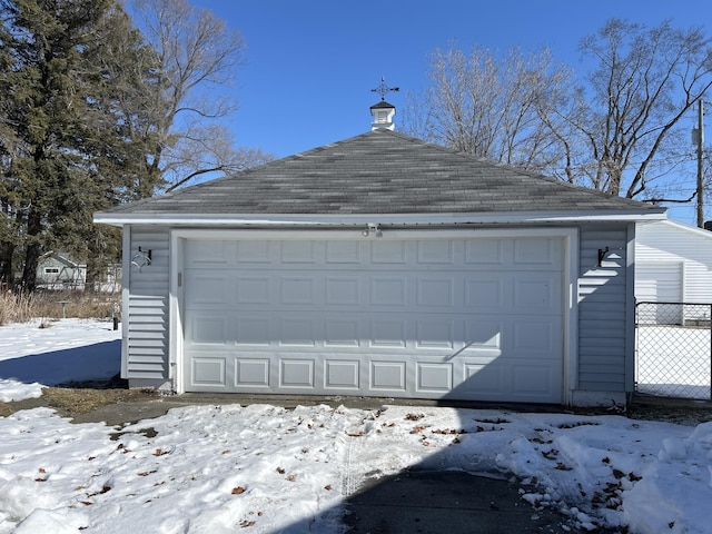 snow covered garage featuring a detached garage