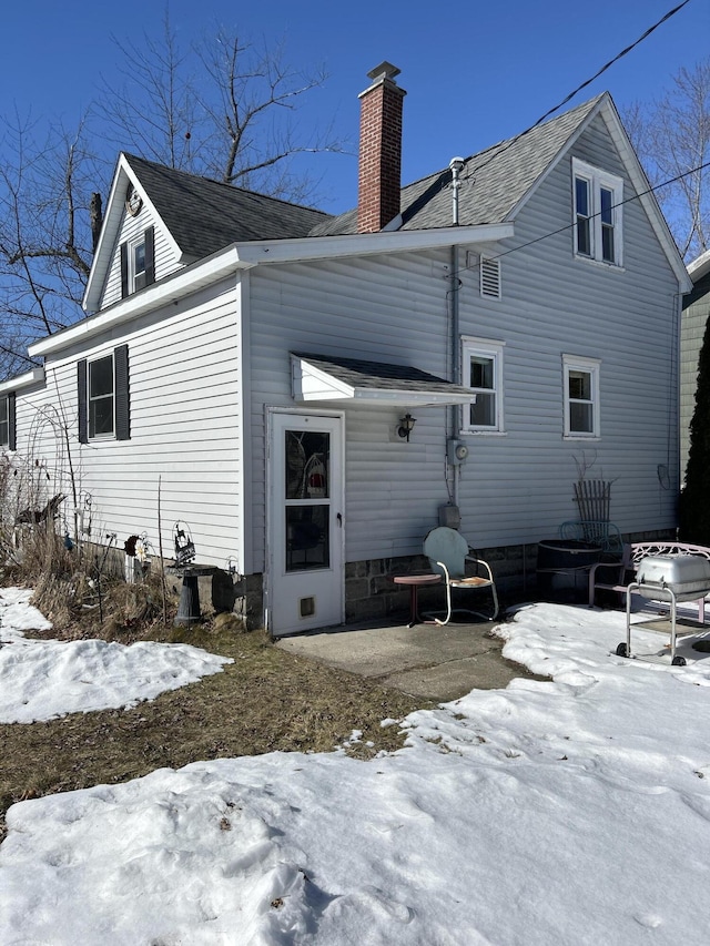 snow covered property featuring a chimney