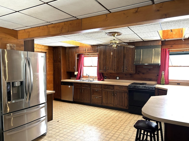 8610 Lincoln Bay Dr, Alpena, MI 49707 - kitchen featuring plenty of natural light, wooden walls, appliances with stainless steel finishes, light countertops, and light floors