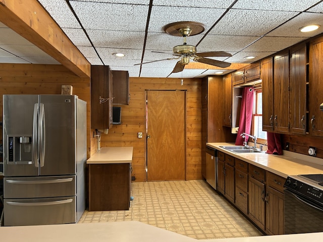 8610 Lincoln Bay Dr, Alpena, MI 49707 - kitchen with wooden walls, light countertops, appliances with stainless steel finishes, a ceiling fan, and a sink