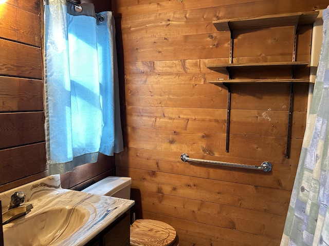 8610 Lincoln Bay Dr, Alpena, MI 49707 - bathroom with wooden walls, toilet, curtained shower, and vanity