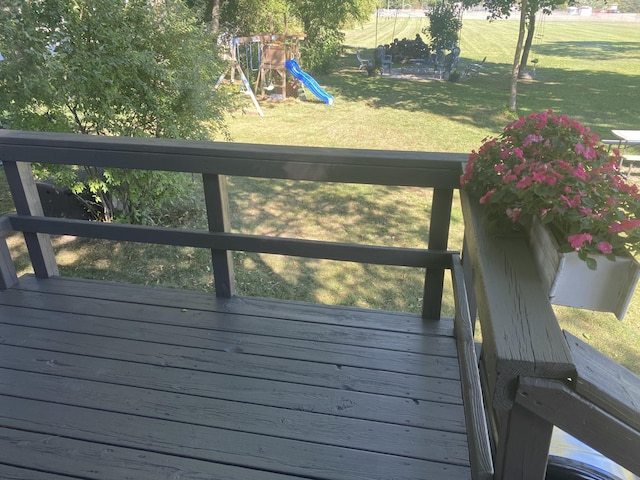 wooden deck with a playground and a yard