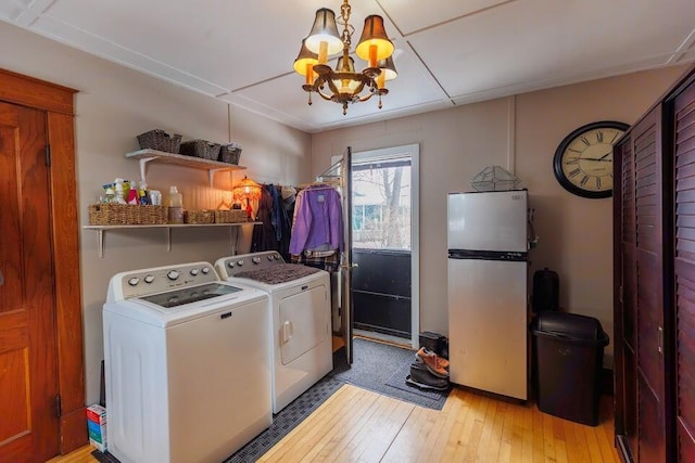 laundry area featuring a chandelier, separate washer and dryer, light wood-style flooring, and laundry area