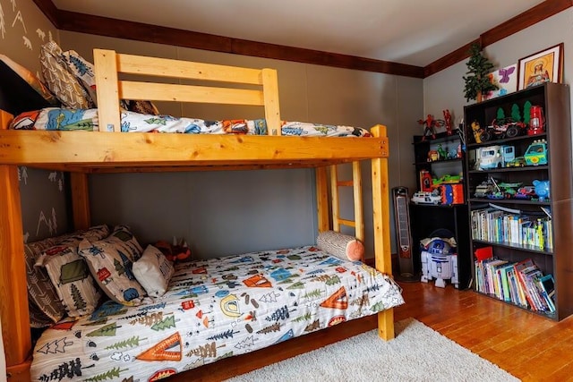 bedroom featuring wood finished floors and ornamental molding