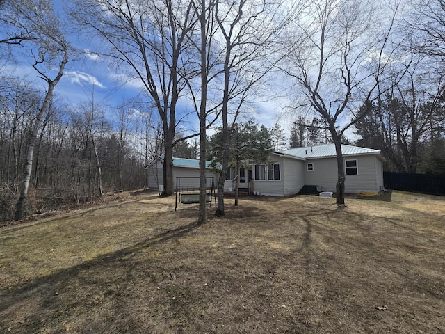 view of yard featuring fence and an outbuilding