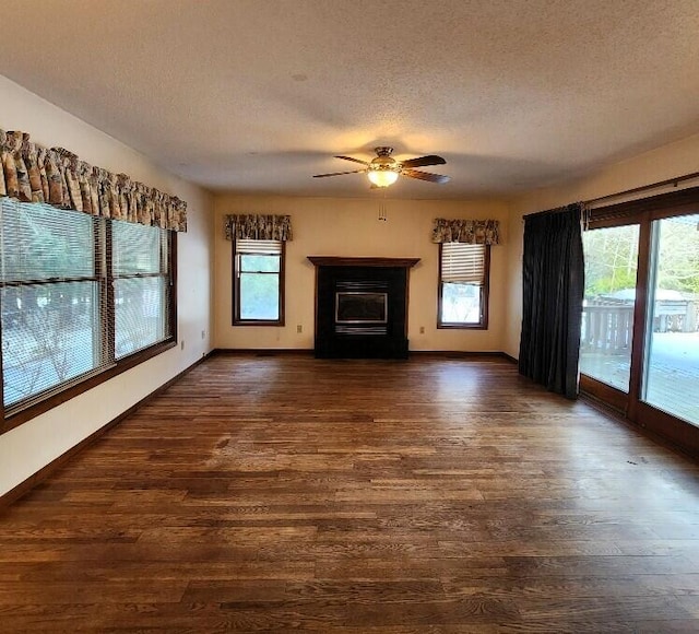 unfurnished living room with dark wood finished floors, baseboards, a textured ceiling, and ceiling fan