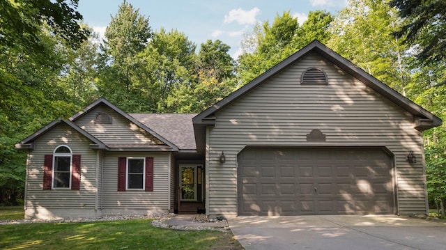 view of front of property with a front yard, concrete driveway, an attached garage, and a shingled roof