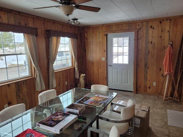 dining room featuring wooden walls and ceiling fan