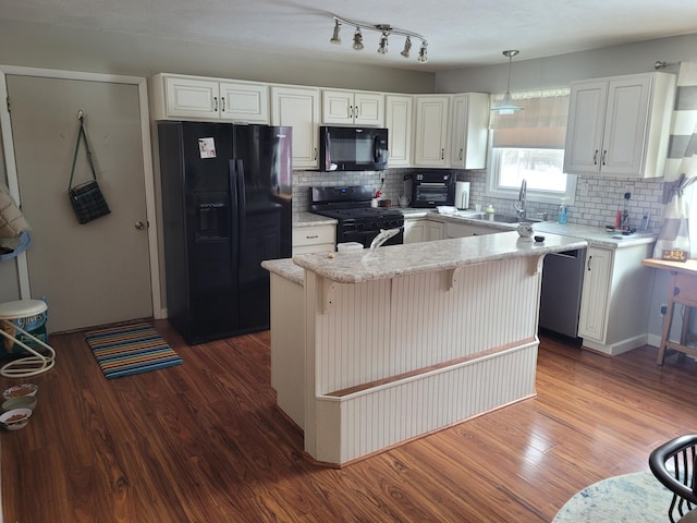 kitchen with dark wood-style floors, white cabinetry, black appliances, and a sink