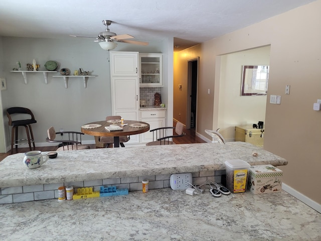 kitchen with a ceiling fan, open shelves, white cabinets, decorative backsplash, and baseboards