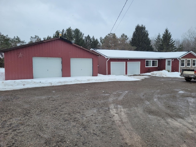 snow covered garage featuring a garage