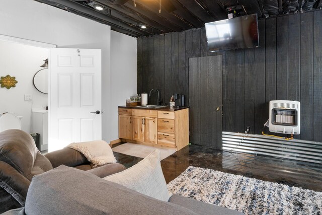 living room featuring heating unit, finished concrete flooring, and wood walls