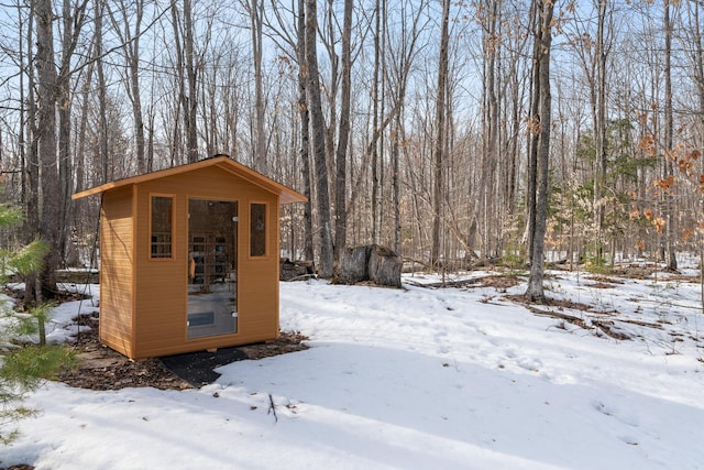 snow covered structure featuring an outdoor structure