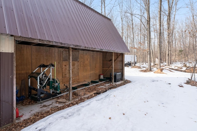 snow covered structure featuring an outdoor structure and a pole building