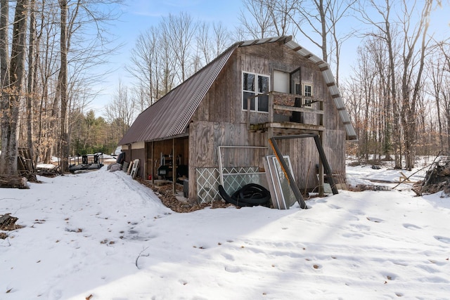 snow covered structure with a barn and an outbuilding