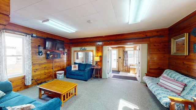 carpeted living area with wooden walls