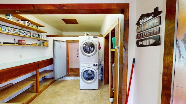 clothes washing area featuring stacked washer / dryer and laundry area