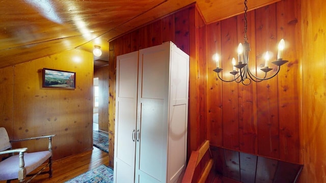 hall with wood ceiling, wood finished floors, and wood walls