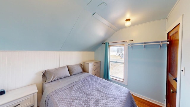 bedroom with wood finished floors and vaulted ceiling