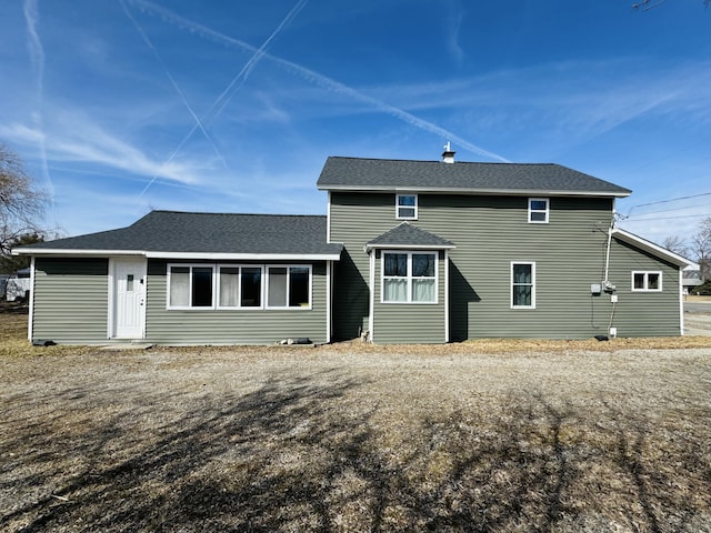 rear view of property featuring roof with shingles